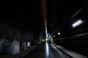 Tekniker installerar nätverksutrustning i en upplyst tunnelmiljö